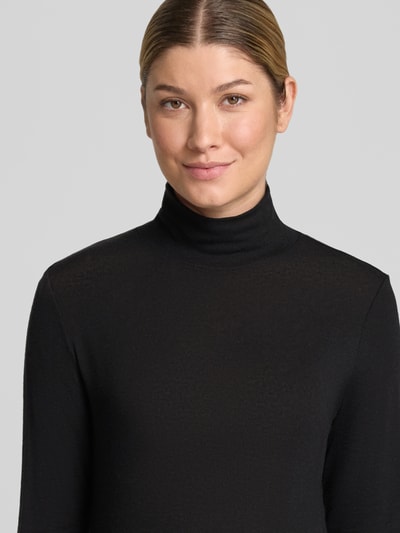 Frauenmodel trägt Longsleeve aus Lyocell-Mix mit Stehkragen von windsor., Farbe Schwarz, glatte Textur, Nahaufnahme Oberkörper. Damen Longsleeve, Slim Fit, Baumwoll-Anteil, Rückenlänge 56 cm bei Größe 36.