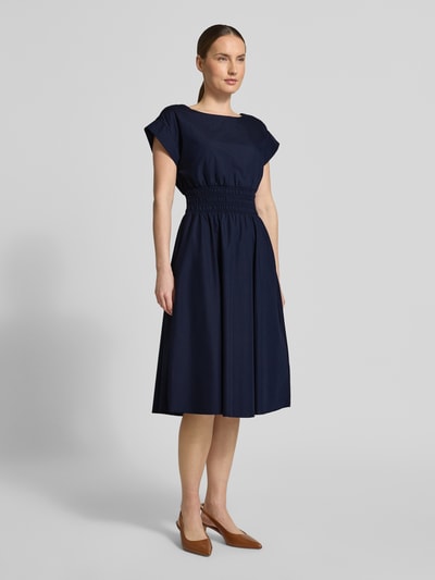 Frauenmodel trägt knielanges Kleid mit Rundhalsausschnitt von Christian Berg Woman Selection aus Material-Mix mit Baumwoll-Anteil, taillierter Schnitt, Kappärmel, elastisches Taillenband, Farbe Dunkelblau, glatte Textur, Ganzkörperansicht von vorne. Rückenlänge bei Größe 36: 110 cm, Brustweite: 34 cm.