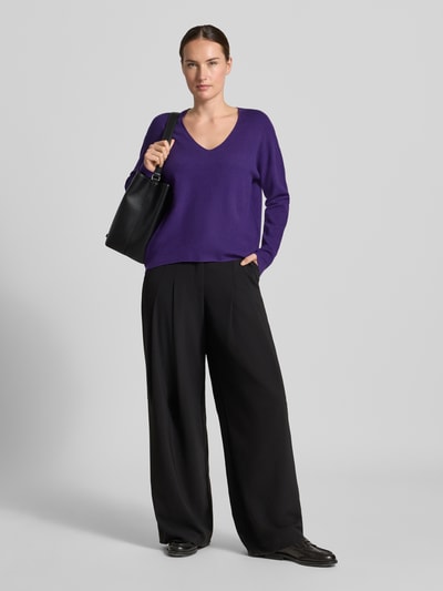 Vrouwenmodel draagt gebreide pullover uit Viscosemix Model 'FREYJA' van Oui, los model, V-hals, dames, ruglengte maat 36 60 cm, mouwlengte 50 cm, paarse kleur, gladde textuur, zwarte broek, zwart accessoire, effen achtergrond, volledig lichaam vooraanzicht.