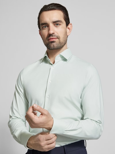Männermodel trägt Slim Fit Business-Hemd mit Kentkragen von OLYMP Level Five in Hellgrün, elastischer Baumwoll-Mix, Nahaufnahme Oberkörper.