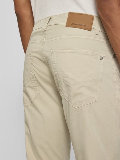 Männermodel trägt Tapered Fit Hose mit Eingrifftaschen Modell 'Lyon' von Pierre Cardin aus beigefarbenem Baumwoll-Elasthan-Mix, Nahaufnahme Rückansicht. Bundweite 43 cm, Innenbeinlänge 79 cm bei Größe 32/32.