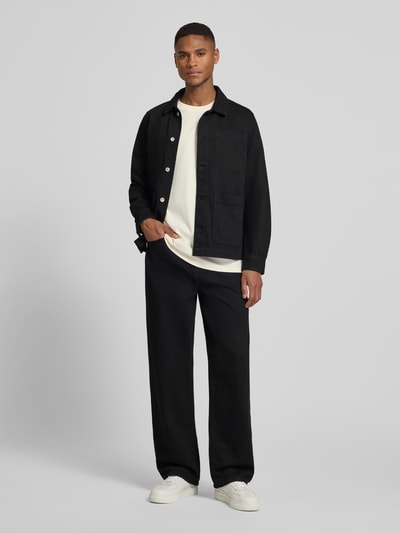 Männermodel trägt Regular Fit Overshirt mit Brusttasche Modell 'Layton' von Les Deux in Schwarz aus Reine Baumwolle, Ganzkörperansicht von vorne.