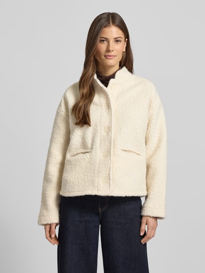 Frauenmodel trägt cremeweiße Jacke aus Teddyfell Modell 'SHAIMA' von Soyaconcept, Regular Fit, verdeckte Knopfleiste, Eingrifftaschen, Ganzkörperansicht von vorne.