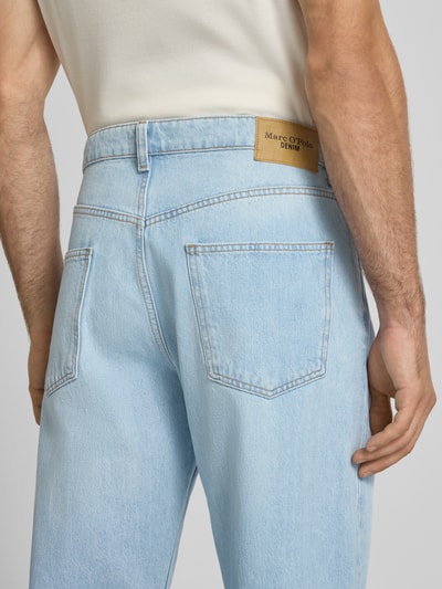 Männermodel trägt Wide & Loose Fit Jeans aus reiner Baumwolle von Marc O'Polo DENIM, helle Waschung, blaue Denim-Textur, Detailaufnahme Rückansicht.