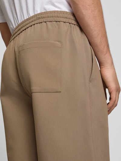 Mannenmodel draagt Loose Fit Shorts met elastische tailleband model 'WILL' van Only & Sons, uni, met steekzakken, detailopname rug.