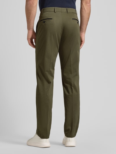 Männermodel trägt olivgrüne Herren Chino mit Eingrifftaschen Modell 'Peaker' von Hiltl aus Baumwoll-Elasthan-Mix, Regular-Fit, Ganzkörperansicht Rückansicht.