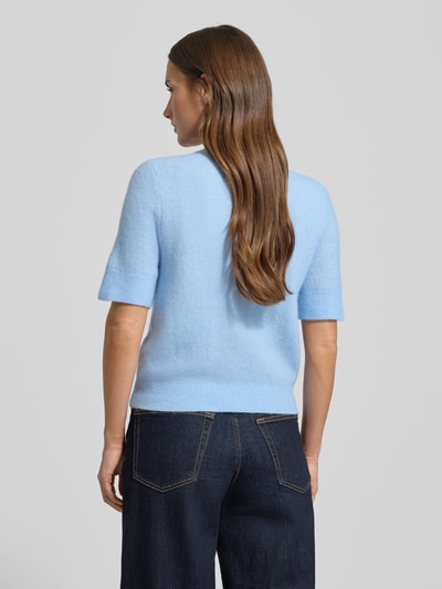 Frauenmodel trägt Strickjacke mit Knopfleiste Modell 'NOURA' von Samsøe Samsøe, Woll-Alpaka-Mix, Regular-Fit, hellblau, Rückenansicht.