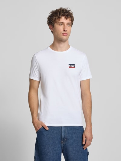 Männermodel trägt weißes Slim Fit T-Shirt-Set aus reiner Baumwolle im 2er-Pack von Levi's®, glatter Stoff, Ganzkörperansicht von vorne.