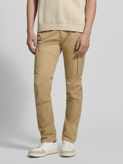 Männermodel trägt Regular Fit Cargohose aus Baumwoll-Mix von s.Oliver RED LABEL in Optik: Unifarben mit Label-Patch, Nieten und Cargotaschen, Ganzkörperansicht von vorne.