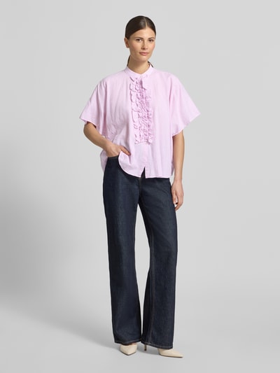 Kobiece model prezentuje bluzka Relaxed Fit Bluse mit Rüschen Modell 'DAISY' von 0039 Italy z mieszanki lnu i bawełny, jasnoróżowa, stójka, falbany, długość tyłu w rozmiarze S: 66 cm, długość rękawów w rozmiarze S: 26 cm, pełen widok z przodu.