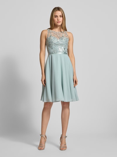 Frauenmodel trägt Cocktailkleid mit floraler Stickerei von LUXUAR FASHION, Gerader-Schnitt, Knielänge, Rundhalsausschnitt, Paillettenbesatz, zartes Blau, glatter Chiffon, Ganzkörperansicht von vorne.