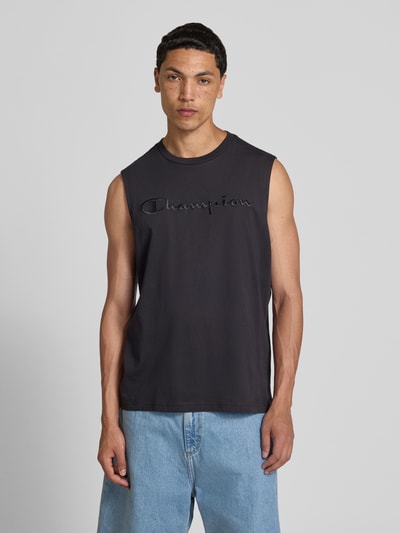 Männermodel trägt Top mit Label-Stitching und Rundhalsausschnitt von CHAMPION, Reine Baumwolle, Regular-Fit, schwarze Farbe, Ganzkörperansicht von vorne.