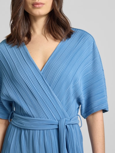 Kobiece model nosi Regular Fit Jumpsuit mit V-Ausschnitt Modell 'Olinda' od YAS, plisowana faktura, taliowany, pasek z materiału, niebieski, z krótkim rękawem, zdjęcie: zbliżenie na górną część ciała.