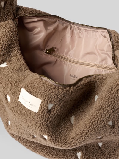 Produktfoto, Cross Body Bag mit Label-Patch von Studio Noos aus braunem Teddyfell mit hellem Innenfutter, Reißverschluss, Label-Patch, Reißverschlussfach innen, Herzmuster, 62x35x11 cm, Schulterriemen 80 cm.