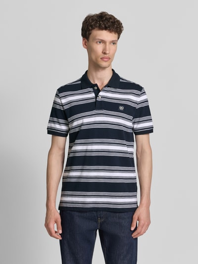 Männermodel trägt Regular Fit Poloshirt mit Label-Patch von Lerros in gestreiftem Dunkelblau-Weiß, Reine Baumwolle, Knopfleiste, Ganzkörperansicht von vorne.