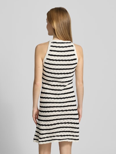 Vrouwenmodel draagt knielanges Kleid in Strick-Optik van REVIEW, zwart-witte strepen, puur katoen, nauwsluitende pasvorm, semi-transparant, mouwloos design, ronde hals, ruglengte maat S 92 cm, borstwijdte maat S 40 cm, gebreide structuur, Ganzkörperansicht Rückansicht.