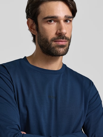 Männermodel trägt Regular Fit Langarmshirt aus Baumwoll-Mix Modell 'TCHARK' von BOSS Orange, Optik: Unifarben, Nahaufnahme Oberkörper.