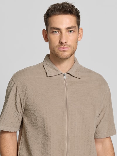 Männermodel trägt Regular Fit Freizeithemd mit Strukturmuster von JAKE*S STUDIO MEN, beiger Baumwoll-Mix, Kentkragen, Reißverschluss, Nahaufnahme Oberkörper.