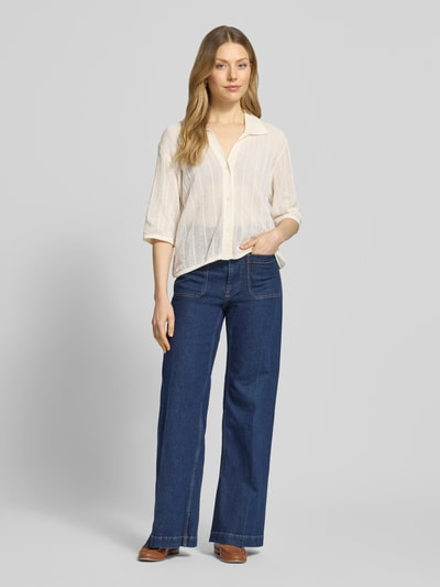 Kobiece modelka nosi Regular Fit Hemdbluse in Lochmuster Modell 'Alva' od Mustang z bawełny, kołnierzyk koszulowy, rękaw o dł. 1/2, listwa guzikowa, elastyczne wykończenia, długość tyłu w rozmiarze S: 52 cm, długość rękawów w rozmiarze S: 33 cm, jasny kolor, tekstura ażurowa, całkowity widok z przodu.