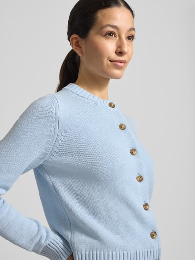 Modelka kobieca nosi Strickjacke mit Rundhalsausschnitt und Knopfleiste von Jake*s Casual, mieszanka bawełny, krój regular fit, okrągły dekolt, listwa guzikowa, długość tyłu w rozmiarze S: 53 cm, długość rękawów w rozmiarze S: 65 cm, jasnoniebieski, gładka tekstura, widok na górną połowę ciała z przodu