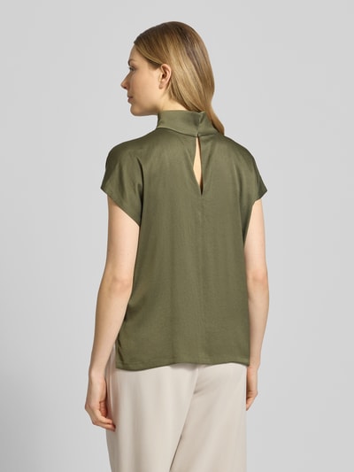 Kobiece modelka ma na sobie Blusenshirt mit Stehkragen Modell 'ALARIA' von Drykorn, mieszanka materiałów z dodatkiem streczu, krój regular fit, długość tyłu w rozmiarze 36: 59 cm, oliwkowozielony, gładka faktura, widok całej sylwetki z tyłu.