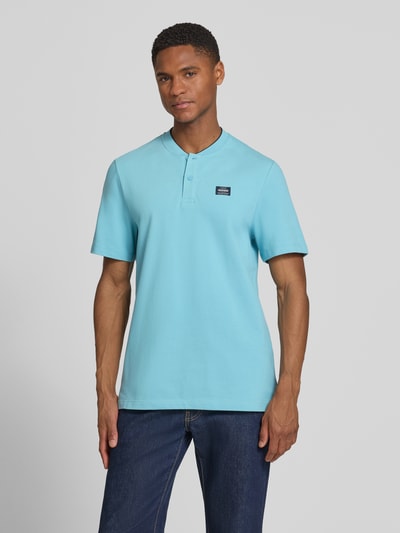 Männermodel trägt Regular Fit Poloshirt aus Baumwoll-Mix von s.Oliver RED LABEL in Optik: Unifarben, Piqué-Struktur, Kurzarm, Ganzkörperansicht von vorne.