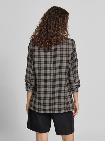 Kobieta nosi Shaped Fit Longblazer mit Schalkragen model 'BOSELLA' od PIECES w czarno-szaro-brązową kratę, tekstura gładka, widok całej sylwetki od tyłu.