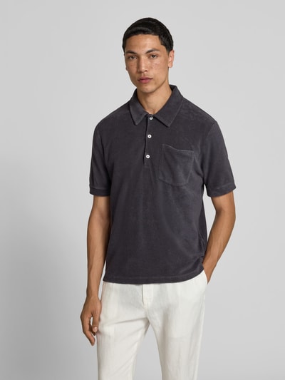 Männermodel trägt Regular Fit Poloshirt aus Baumwoll-Mix von Closed in Dunkelgrau mit Polokragen und Brusttasche, Ganzkörperansicht von vorne.