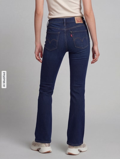 Frauenmodel trägt Bootcut Jeans aus Baumwoll-Mix Modell '315®' von Levi's® 300 in Denim-Optik mit Label Patch, Ganzkörperansicht Rückansicht, KI-modifiziertes Bild.