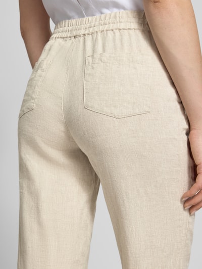Frauenmodel trägt Leinenhose mit elastischem Bund und Gesäßtaschen von Christian Berg Woman in Beige, Stoffstruktur klar erkennbar, Nahaufnahme Rückansicht. Damen, Reines Leinen, Regular-Fit.