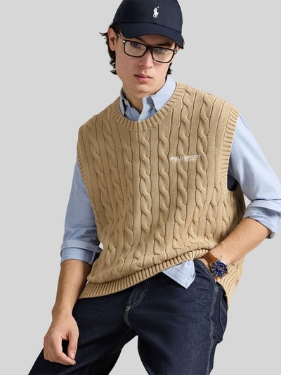 Männermodel trägt Regular Fit Pullunder aus reiner Baumwolle von Polo Ralph Lauren, beżowy, wzór w warkocze, dzianina, crew neck, logo, ganzkörperansicht von vorne.