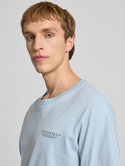 Männermodel trägt T-Shirt mit Label-Print und Rundhalsausschnitt von Jack & Jones aus reiner Baumwolle im Regular-Fit, Nahaufnahme Oberkörper.