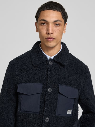 Männermodel trägt Regular Fit Hemdjacke mit Brustleistentaschen von Marc O'Polo DENIM in Dunkelblau, grobe Textur, Nahaufnahme Oberkörper.