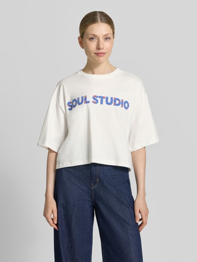 Vrouwenmodel draagt Cropped Boxy Fit T-Shirt met Label-Print van Smith and Soul, witte katoen, boxy fit, ronde hals, labelprint, ruglengte maat S 48 cm, voorkant, close-up bovenlichaam.