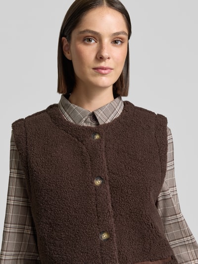Vrouwenmodel draagt bodywarmer van teddybont in bruin van FREE/QUENT, Model 'Eddy', regular fit, met paspelzakken, Nahaufnahme Oberkörper.