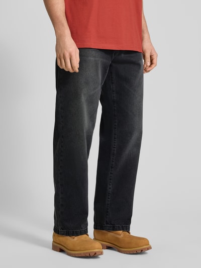 Männermodel trägt Jeans im 5-Pocket-Design Modell 'Landon' von Carhartt Work In Progress in Schwarz, Straight Fit, Nahaufnahme Unterkörper.