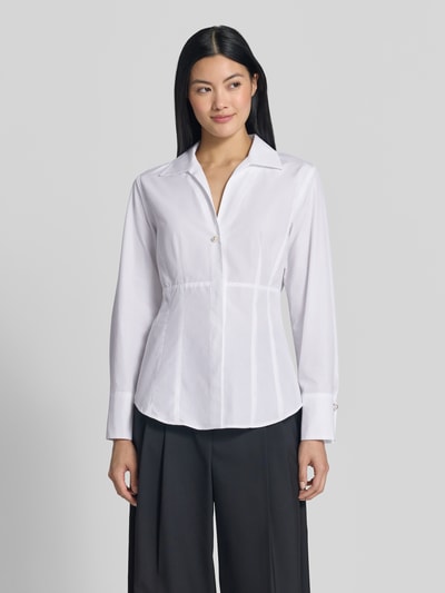 Frauenmodel trägt Slim Fit Hemdbluse aus reiner Baumwolle von Marella in Weiß mit Ziernähten und Perlenknopf, Ganzkörperansicht von vorne. Taillierte Passform, Hemdblusenkragen, langärmlig, glatte Struktur, Kontext: Damen Hemdbluse von Marella, reine Baumwolle, Slim Fit, tailliert, Knopfverschluss mit Perlenbesatz, Rückenlänge 53 cm, Ärmellänge 60 cm.