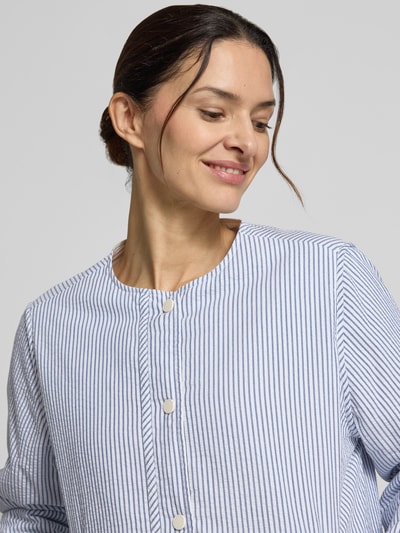 Frauenmodel trägt Jacke mit Rundhalsausschnitt Modell 'GABI' von ECOALF aus reiner Baumwolle, feine weiße und blaue Streifen, Nahaufnahme Oberkörper.
