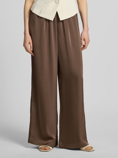 Frauenmodel trägt Wide Leg Stoffhose aus Baumwoll-Mix Modell 'LUCA' von VILLA SOPHIE, Optik: Unifarben, Passform: Wide Leg, Applikation: Label-Patch, Bundabschluss: elastisch, Taschen: seitliche Eingrifftaschen, Nahaufnahme Unterkörper, Vorderansicht.