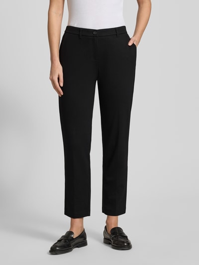 Frauenmodel trägt Chino aus Viskose-Mix mit Gesäßtaschen von Christian Berg Woman, czarny kolor, regular fit, kieszonki z tyłu, widok z przodu, całkowita długość nogawki 71 cm, obwód pasa 40 cm, materiał elastyczny. Ganzkörperansicht von vorne.