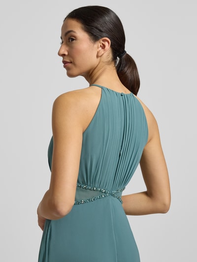 Modelka kobieca nosi Regular Fit Abendkleid mit Ziersteinbesatz od Jake*s Cocktail, zielony, krój regular fit, półprzezroczyste partie, ozdobne fałdy, szerokość w rozmiarze 36: 38 cm, długość pleców 156 cm, widok z tyłu na górną część sylwetki.