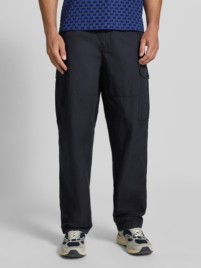Mannenmodel draagt Wide Fit Cargo-broek met katoenmix van Armani Exchange in zwart met cargozakken en elastische band, frontaal totaalaanzicht. Bandwijdte maat 32/32: 45 cm, binnenbeenlengte: 78 cm.