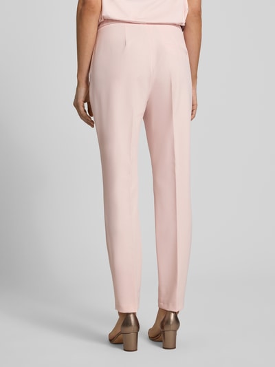Frauenmodel trägt Slim Fit Schmale Hose mit elastischem Bund von s.Oliver BLACK LABEL, Optik: Unifarben, angedeutete Gesäßtaschen, Ganzkörperansicht Rückansicht.