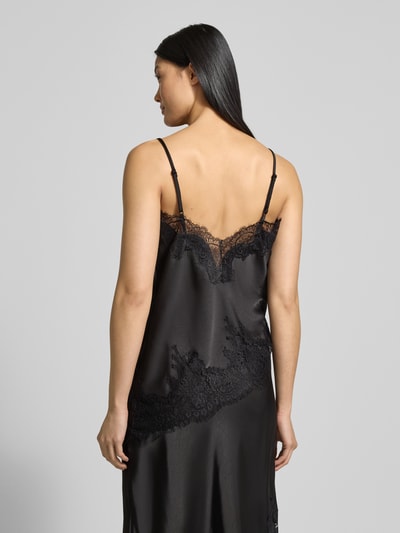 Vrouwenmodel draagt Trägertop met Spitze Model 'Viole' van Neo Noir, materiaalmix met stretch, asymmetrische look, spaghettibandjes, ruglengte bij maat 36 68 cm, zwarte kleur, gladde en kanten texturen, Ganzkörperansicht Rückansicht.