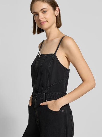 Kobiece model nosi czarny kombinezon Regular Fit Jumpsuit aus reiner Baumwolle model 'SEAMED' od Levi's® 300, zbliżenie na górną część ciała.