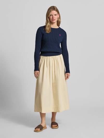 Frauenmodel trägt Strickpullover mit Zopfmuster und Label-Stitching von REVIEW, dunkelblau, Baumwoll-Mix, Regular Fit, Ganzkörperansicht von vorne.