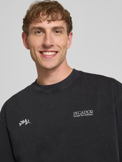 Männermodel trägt Oversized Herren T-Shirt aus reiner Baumwolle mit Label-Print Modell 'Trofa' von PEGADOR, Nahaufnahme Oberkörper.