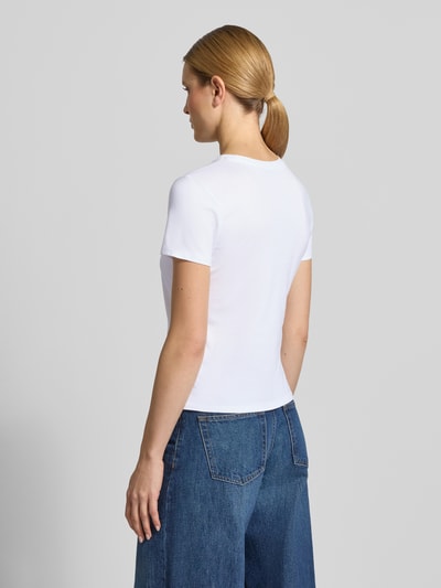 Kobiece modelka nosi Regular Fit T-Shirt aus reiner Baumwolle von Tom Tailor Denim, efekt: jednolity kolor, okrągły dekolt, krótki rękaw, dżersej z bawełny, aplikacja: wyhaftowany napis, widok całej sylwetki z tyłu.