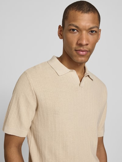 Męski model nosi Regular Fit Poloshirt aus Baumwoll-Leinen-Mix Modell 'MATTIS' od SELECTED HOMME, beżowy, kratkowana faktura, krój regular fit, V-dekolt, krótki rękaw, z przodu, zbliżenie na górną część ciała.