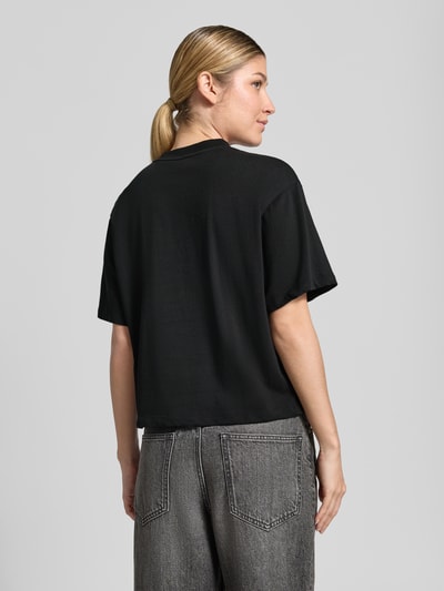 Vrouwenmodel draagt zwart Loose Fit T-Shirt uit pure katoen model 'Duslant' van HUGO voor Dames, volledige lichaamsopname achteraan.